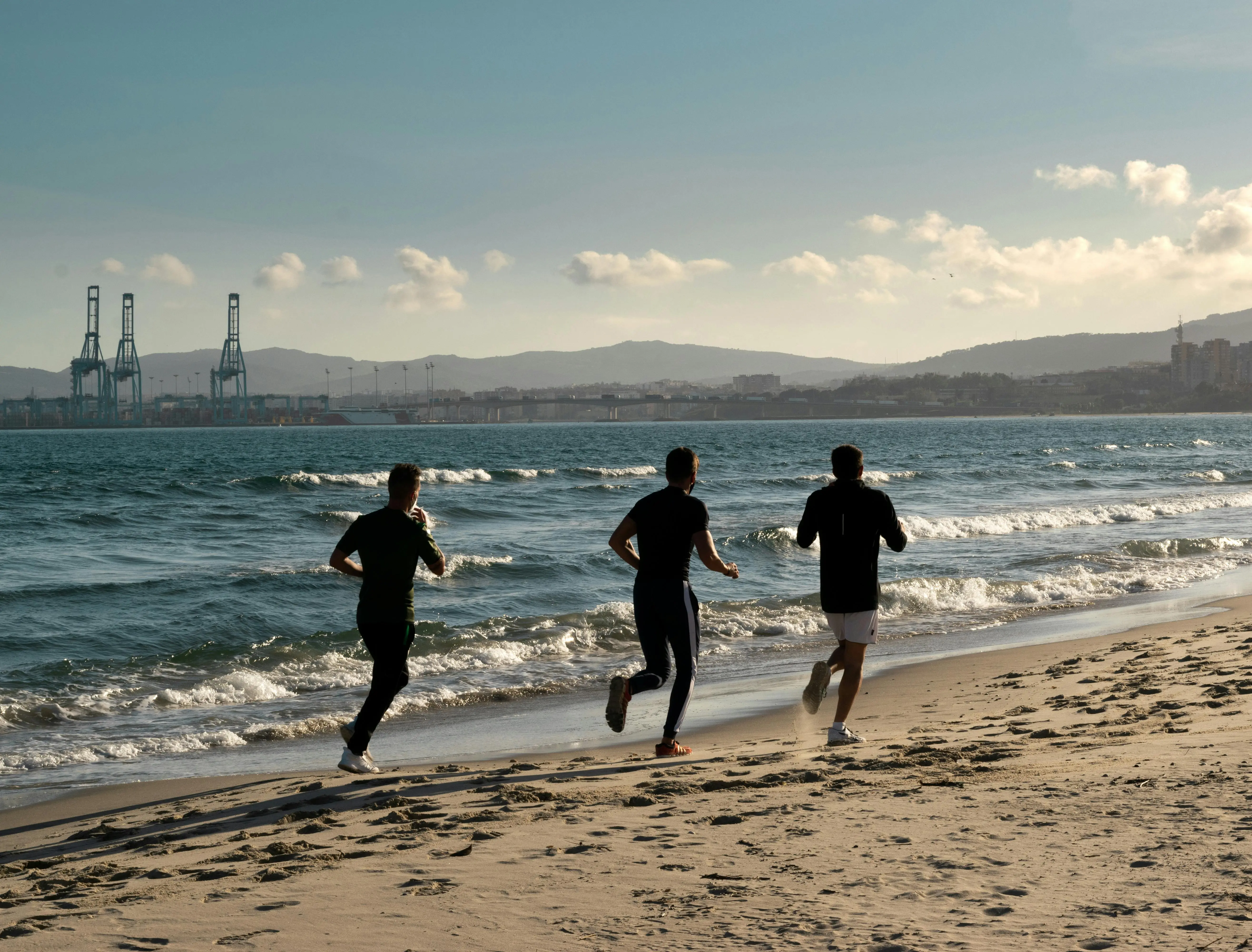 Personas corriendo en la playa de Barcelona
